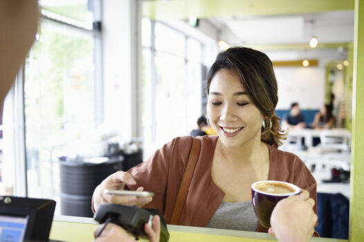 woman using her phone to make coffee payment