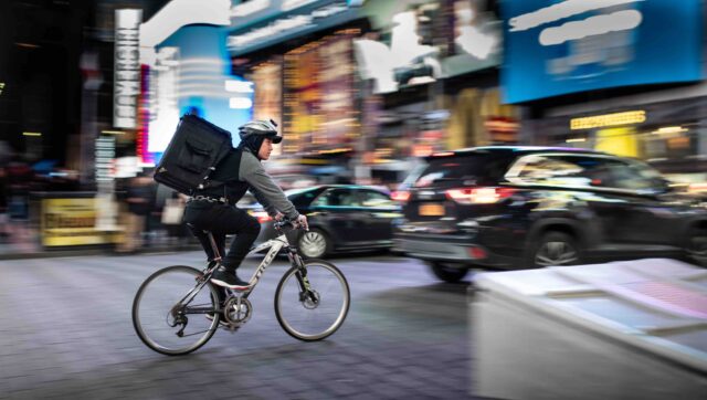 A gig delivery worker on a bike in Asia