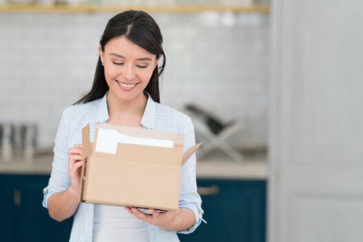 Woman getting a package on the mail from a subscription payment business.