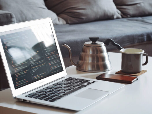 laptop on table with coffee pot and mug