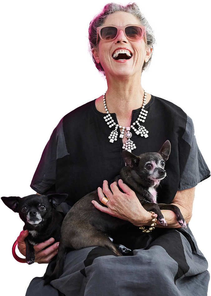 An elderly, smiling lady with dogs in her arms