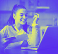 A Woman Works On The Computer And Smiles, Representing The Digital Checkout: How To Accept Credit Card Payments Online