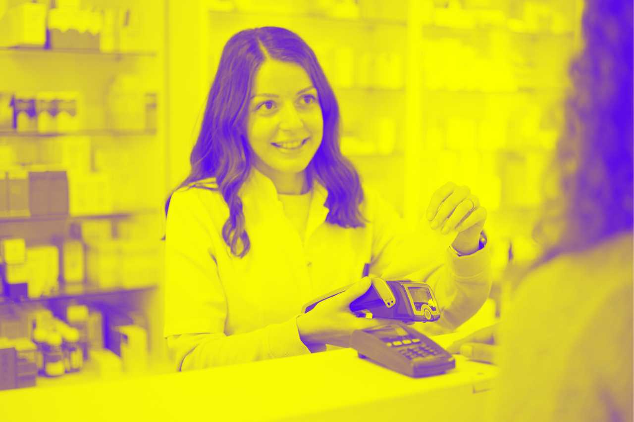 A woman pays at a payment terminal in a pharmacy